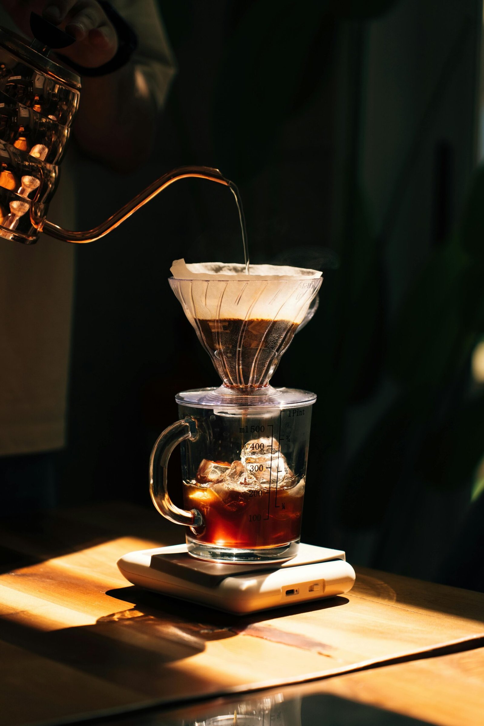 Close-up of a brewing coffee dripper with hot water pouring over coffee in an Ankara café setting.